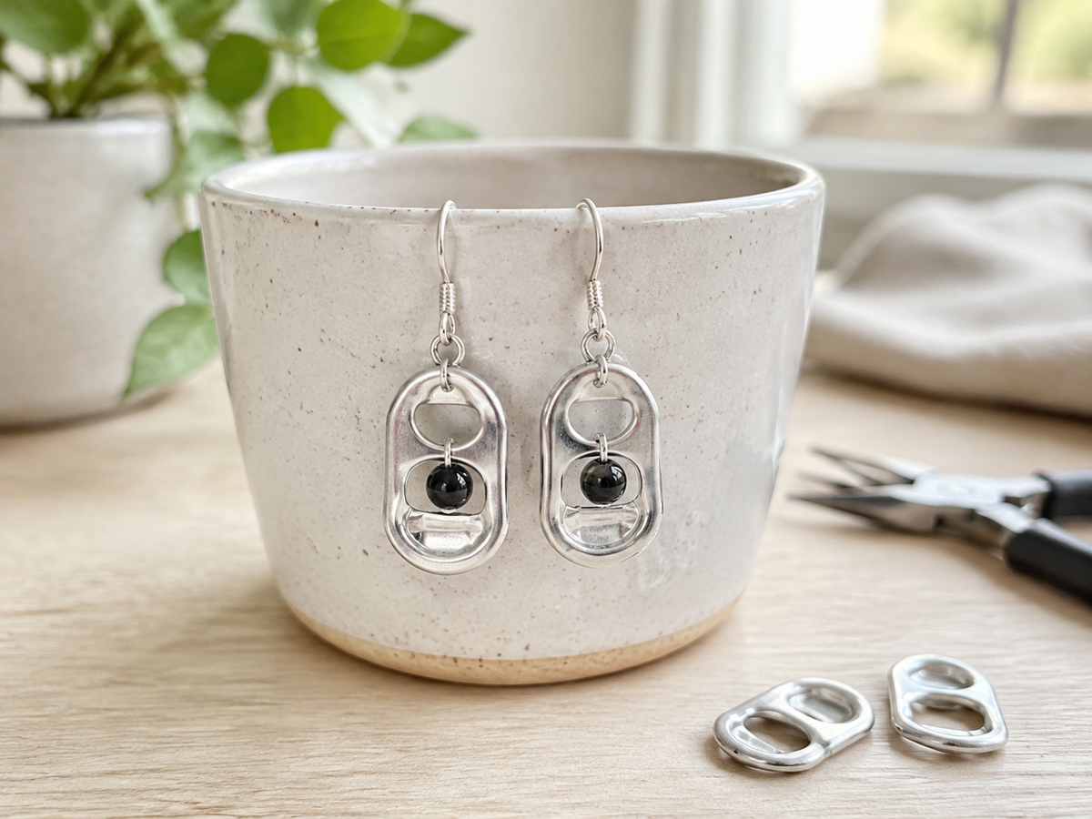 Handmade aluminum soda tab earrings hanging from silver ear wires